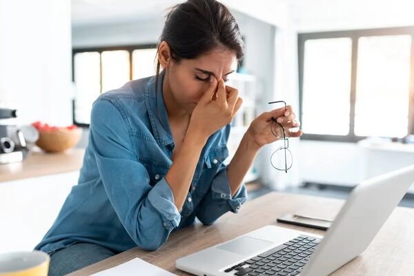 Verpleegkundige typt rapport op laptop na lange werkdag